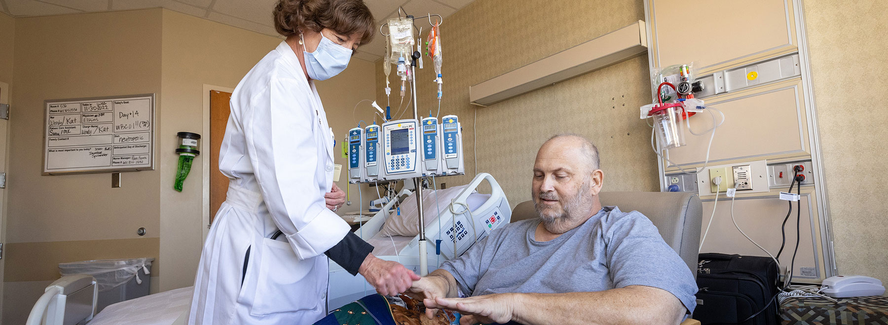 Staff member checking a bone marrow transplant patient's vital signs. Staff member checking a bone marrow transplant patient's vital signs.